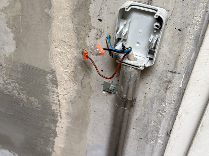 Elektriker bei Kleinreparatur an einer Anschlussdose in Gewerbeobjekt