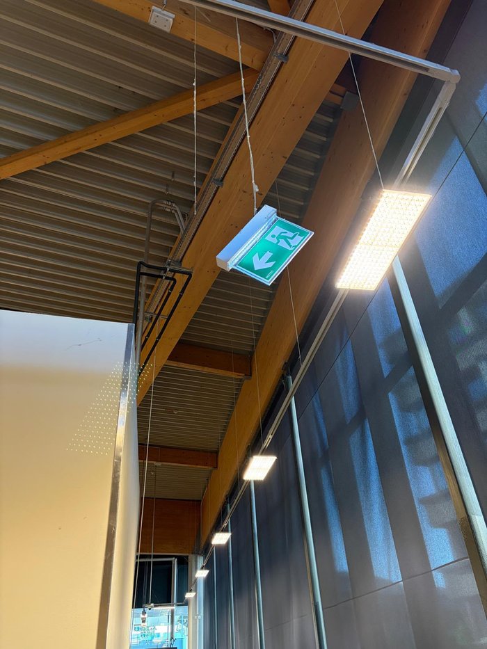 Schräg hängendes Fluchtwegschild – typischer Befund bei der Objektbegehung